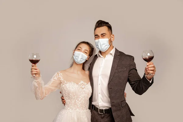 Young Newlyweds Medical Masks Holding Glasses Red Wine Isolated Grey — Zdjęcie stockowe