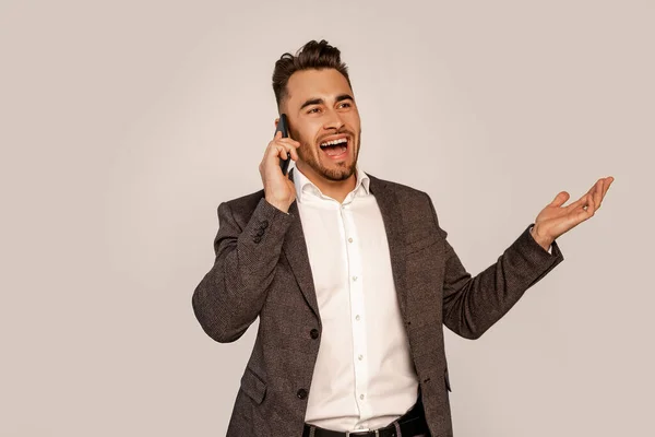Excited Man Gesturing While Talking Smartphone Isolated Grey — Stock Photo, Image