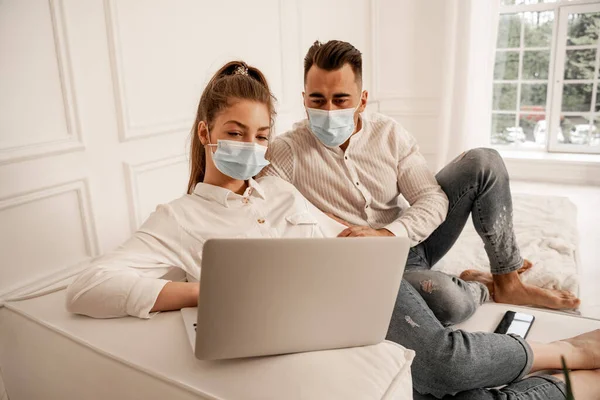Young Couple Medical Masks Watching Movie Laptop Home — Fotografia de Stock