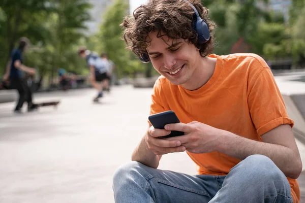 Feliz Joven Los Auriculares Chat Teléfono Móvil Parque Skate — Foto de Stock