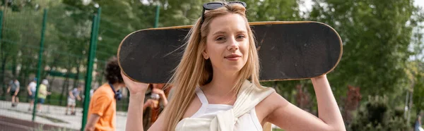 Positieve Blonde Vrouw Met Skateboard Kijken Naar Camera Buiten Banner — Stockfoto