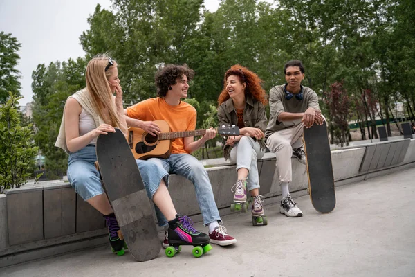 Kudrnatý Muž Hrající Kytaru Šťastným Multietnickým Přátelům Skate Parku — Stock fotografie