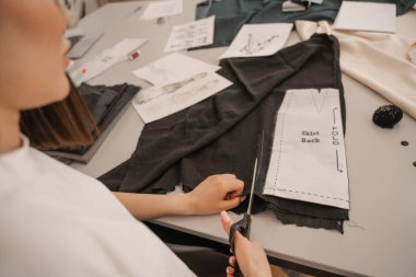 Dikiş deseninin yanında kumaş kesen tasarımcının kırpılmış görünümü 
