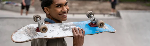 아프리카 미국인 어깨에 스케이트를 카메라를 현수막을 — 스톡 사진