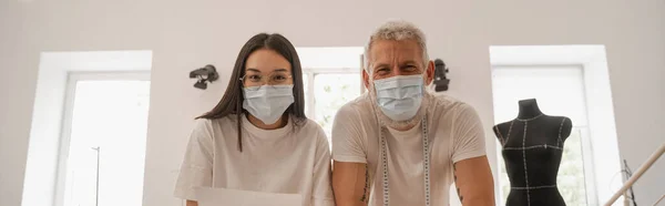 Diseñadores Interraciales Máscaras Médicas Mirando Cámara Taller Pancarta — Foto de Stock