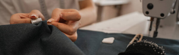 Обрезанный вид швеи с наперстком и ткань работает в ателье, баннер 