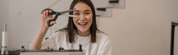 スタジオでミシンはさみを保持笑顔アジアのデザイナー バナー — ストック写真