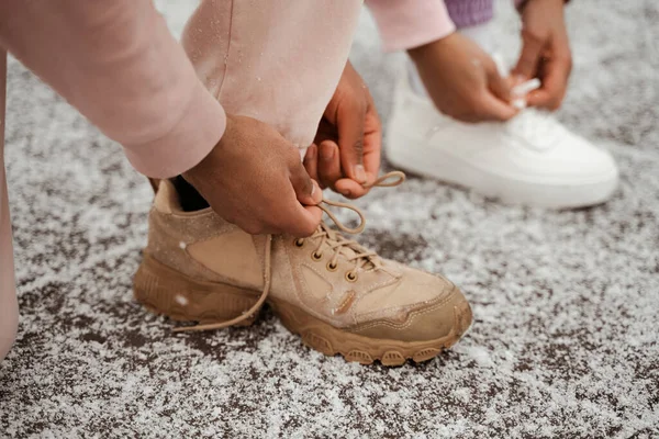 Vista recortada de los atletas afroamericanos atando cordones en zapatillas de deporte - foto de stock