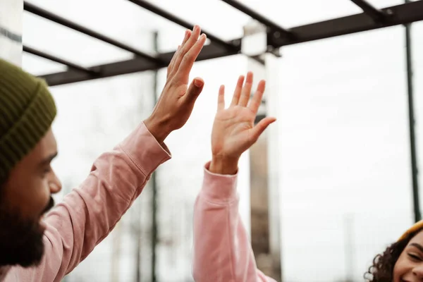 Partial view of young african american athletes giving high five on blurred foreground — Stock Photo