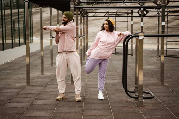 Happy african american athletes warming up on urban sports ground — Stock Photo