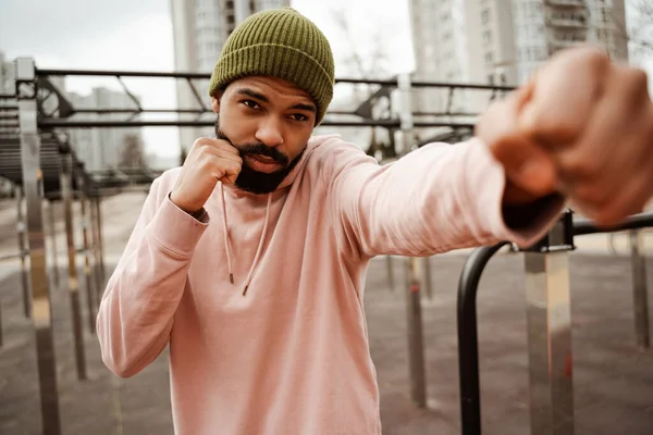 Jeune boxeur afro-américain échauffant à l'extérieur, avant-plan flou — Photo de stock