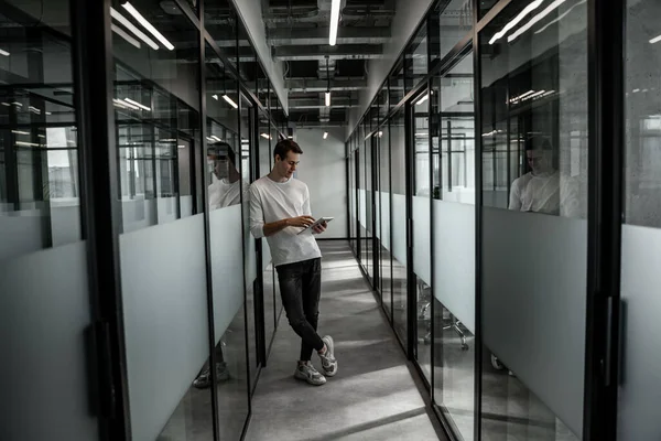 Tutta la lunghezza dello studente in piedi in sala e utilizzando tablet digitale — Foto stock