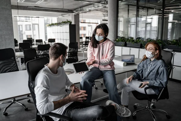 Brünette Studentin zeigt auf digitales Tablet mit leerem Bildschirm in der Nähe von Mitschülern — Stockfoto