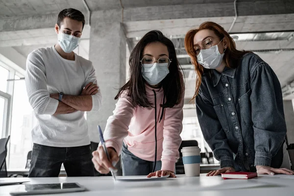 Молодые студенты в медицинских масках, работающие над проектом — Stock Photo