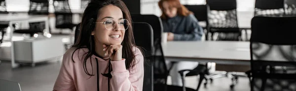 Cheerful brunette student in glasses looking away, banner — Stock Photo