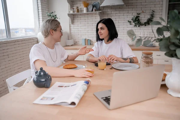 Lesbian couple having conversation during breakfast in kitchen — Stock Photo