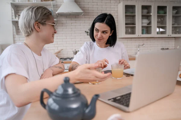 Lesbian couple looking at each other during breakfast in kitchen — Stock Photo