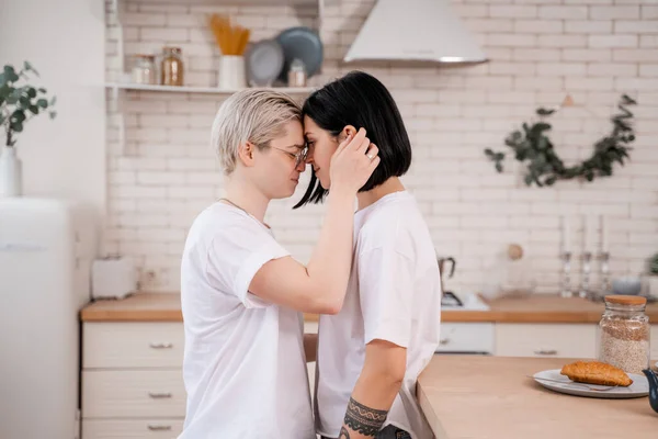 Vue latérale de jeune couple lesbien étreignant dans la cuisine — Photo de stock