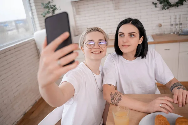 Felice coppia lesbica prendendo selfie in cucina — Foto stock