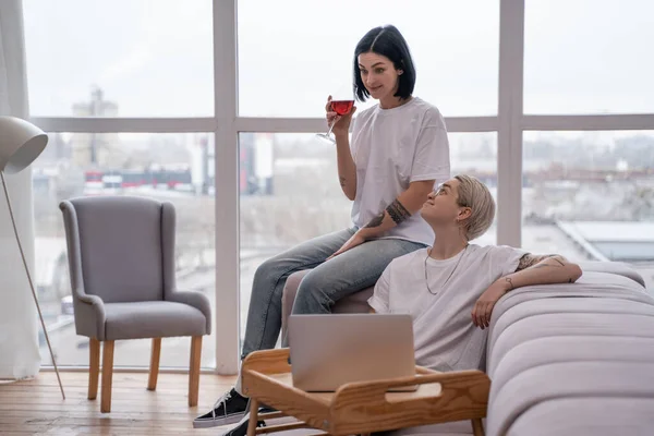Молодая лесбийская пара смотрит кино на ноутбуке в гостиной — стоковое фото