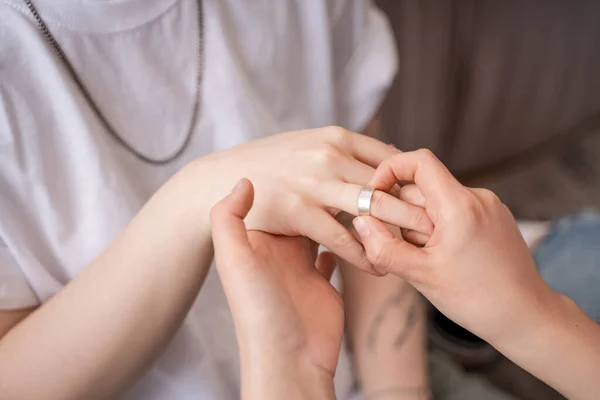 Vista recortada de la mujer que lleva anillo en el dedo de la novia - foto de stock