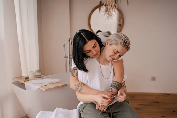 Young lesbian woman hugging with girlfriend holding pregnancy test — Stock Photo