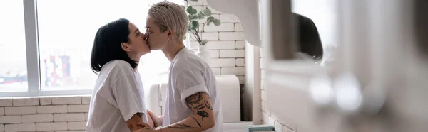 Vista laterale della coppia lesbica che si bacia in cucina, banner — Foto stock