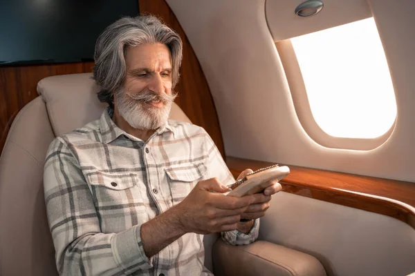 Smiling man playing on mbira in private jet — Stock Photo