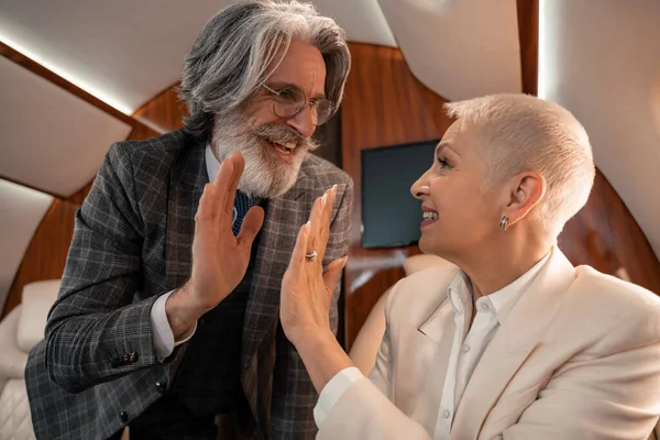 Smiling business people giving high five in private plane — Stock Photo