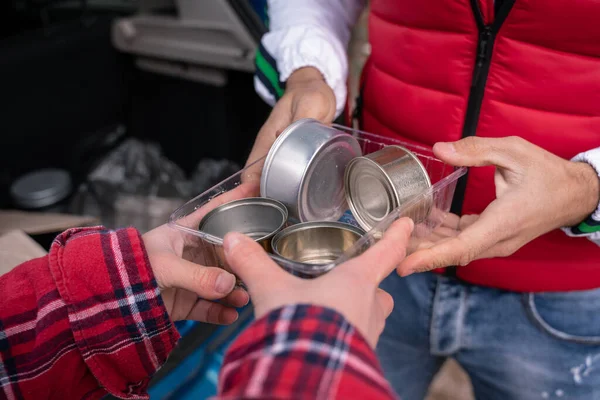 Vista cortada de homem e mulher segurando latas de lata em recipiente de plástico — Fotografia de Stock