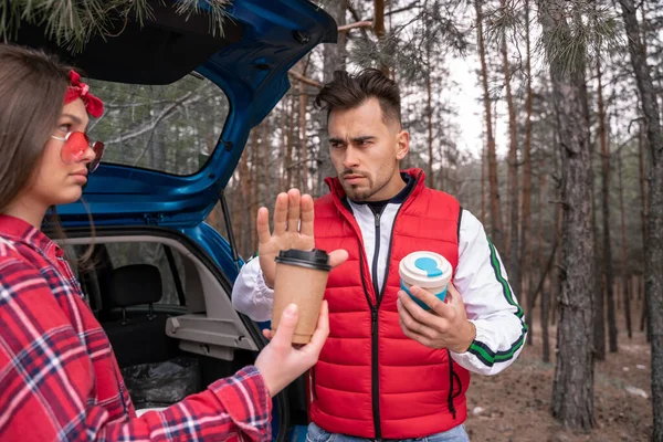 Man showing stop gesture near woman with paper cup outside — Stock Photo