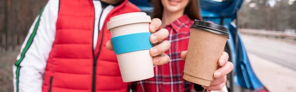 Cropped view of man and woman holding reusable and paper cups, banner — Stock Photo