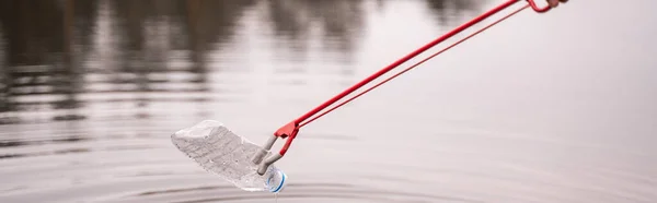 Grabscher holt Plastikflasche aus See, Banner — Stockfoto