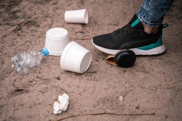 Cropped view of man standing on ground near trash, ecology concept — Stock Photo