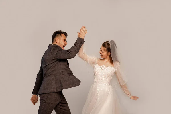 Aufgeregtes Brautpaar gibt High Five isoliert auf Grau mit Fliederton — Stockfoto