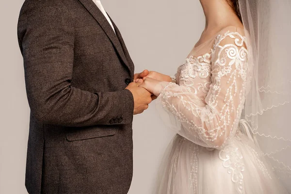 Partial view of newlyweds holding hands isolated on grey — Fotografia de Stock