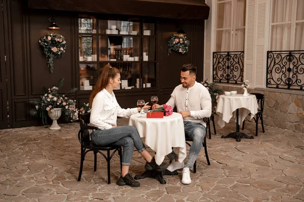 Young couple in jeans talking during date in cafe — Stock Photo