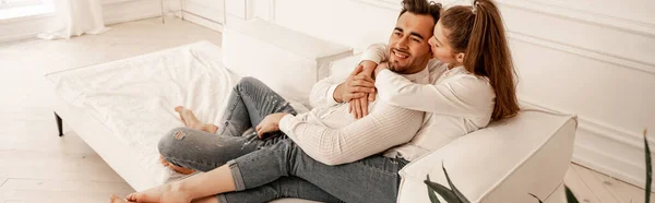 Happy young couple in jeans relaxing on sofa at home, banner — Stock Photo