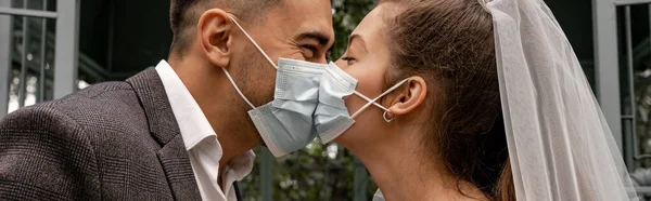Side view of bride and groom in medical masks kissing outdoors, banner — Stock Photo