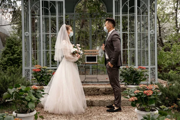 Side view of bride and groom near laptop with blank screen in alcove in park — Stock Photo