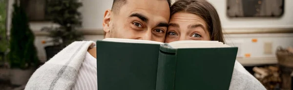 Радостная пара смутные лица с книгой, глядя на камеру на открытом воздухе, баннер — стоковое фото