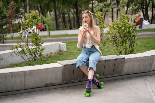 Patinadora loira bebendo coquetel refrescante no parque de skate — Fotografia de Stock