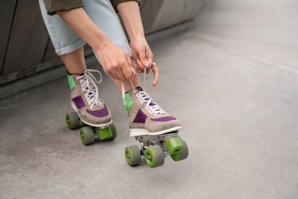 Partial view of woman tying laces on roller skate outdoors — Stock Photo