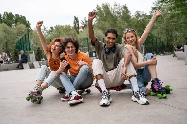 Aufgeregte Multikulti-Skater zeigen Siegergeste auf der Straße im Skatepark — Stockfoto