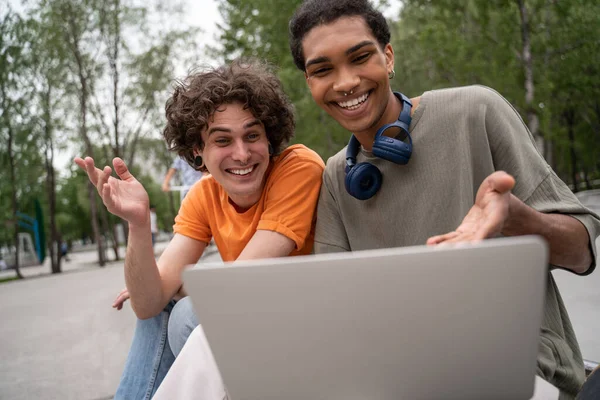 Cheerful interracial friends gesturing during video call outdoors — Stock Photo