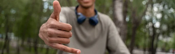 Recortado vista de borrosa afroamericano hombre mostrando colgar gesto suelto, bandera - foto de stock