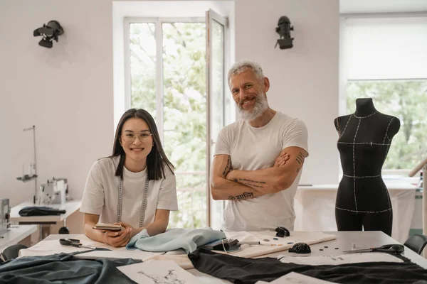 Smiling multiethnic designers looking at camera in workshop — Stock Photo