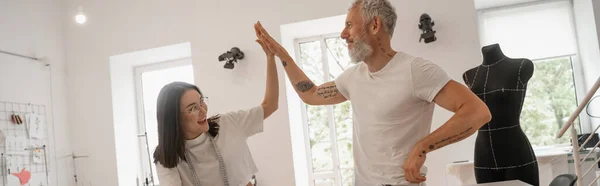 Cheerful interracial designers giving high five in workshop, banner — Stock Photo