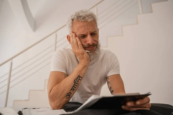 Sad designer looking at clipboard in studio — Stock Photo