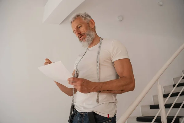 Reifer Designer hält Papier im Atelier — Stockfoto